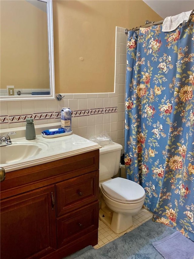 bathroom featuring tile patterned floors, a shower with curtain, vanity, tile walls, and toilet