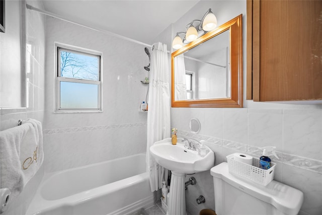 full bathroom featuring toilet, shower / bath combo with shower curtain, tile walls, and tasteful backsplash