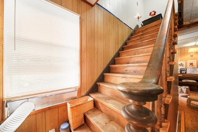 stairway featuring wooden walls and hardwood / wood-style floors