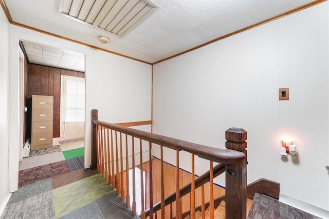 corridor with wood walls and crown molding