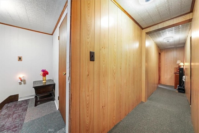 hallway featuring wooden walls, carpet floors, vaulted ceiling, and ornamental molding