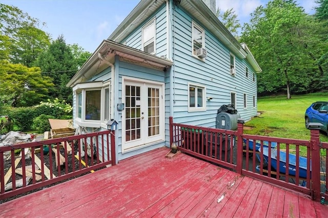 wooden terrace featuring a yard and french doors