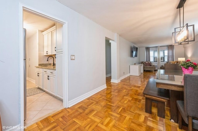 dining space with sink and light parquet floors