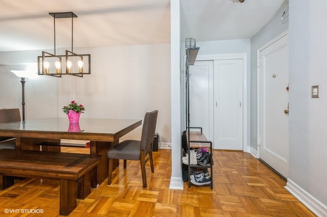 dining room with an inviting chandelier and light parquet floors