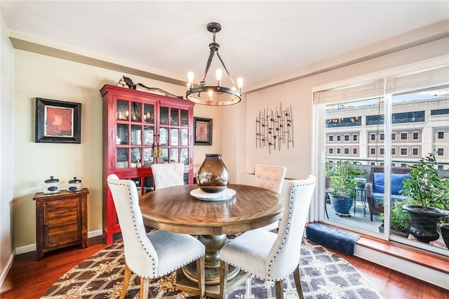 dining room with dark hardwood / wood-style flooring and an inviting chandelier