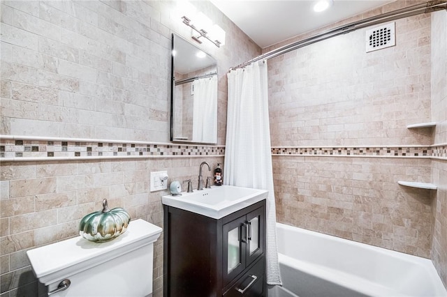 full bathroom with vanity, shower / bath combination with curtain, tile walls, and toilet