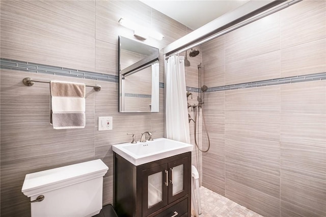 bathroom with curtained shower, vanity, tile walls, and toilet