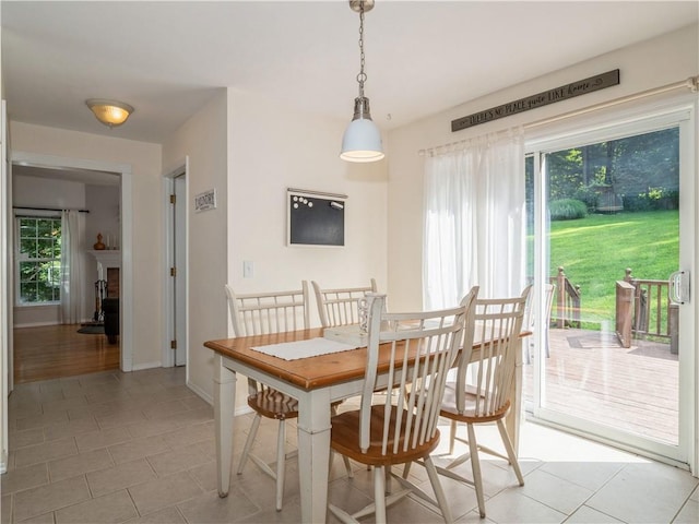 dining area featuring light tile patterned flooring, plenty of natural light, and baseboards