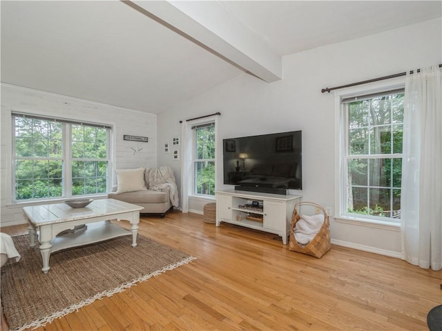 living room featuring lofted ceiling with beams, light wood-type flooring, and baseboards