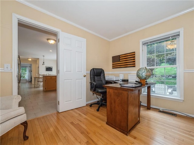 office space featuring ornamental molding, light wood-type flooring, visible vents, and baseboards