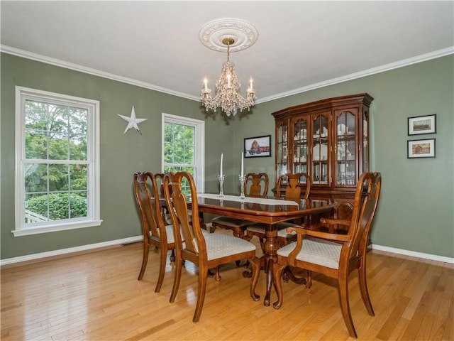 dining room with baseboards, light wood-type flooring, and a notable chandelier