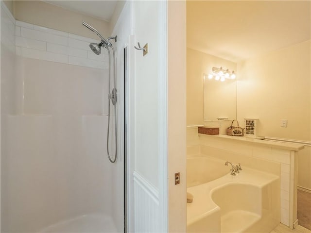 bathroom with a stall shower and a bath