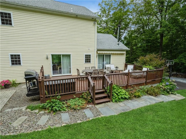 back of property featuring a shingled roof and a wooden deck