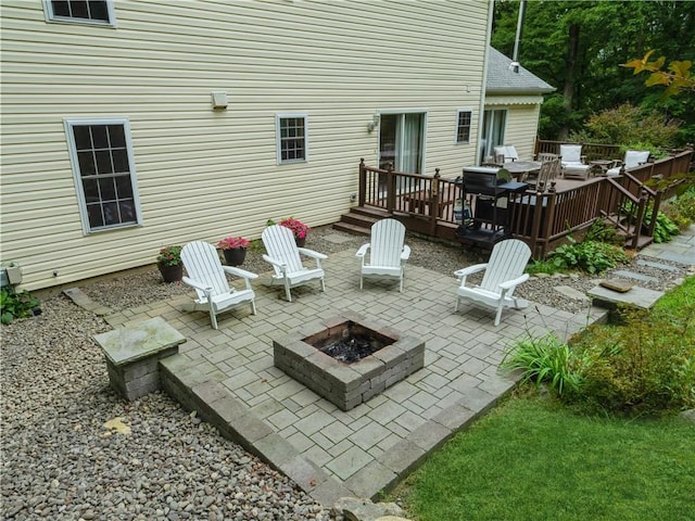 view of patio / terrace with an outdoor fire pit and a deck