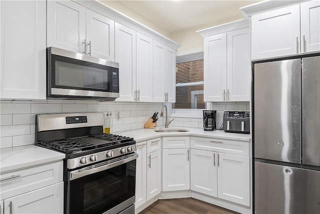 kitchen featuring white cabinetry, light stone countertops, sink, stainless steel appliances, and decorative backsplash