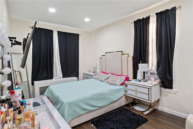 bedroom featuring dark hardwood / wood-style flooring and radiator