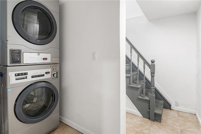 laundry area featuring light tile patterned floors and stacked washer and dryer