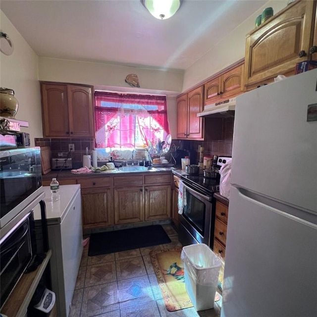 kitchen featuring decorative backsplash, stainless steel appliances, and sink