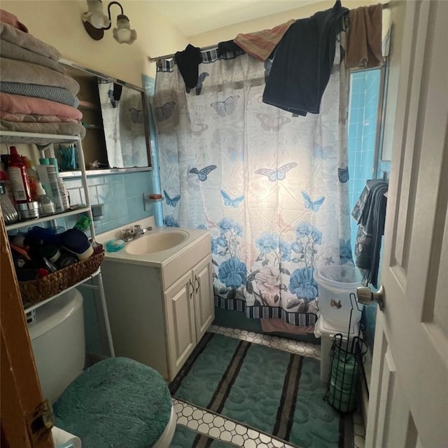 full bathroom featuring vanity, toilet, shower / bath combo with shower curtain, and backsplash