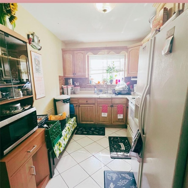 kitchen featuring white appliances, sink, and light tile patterned floors