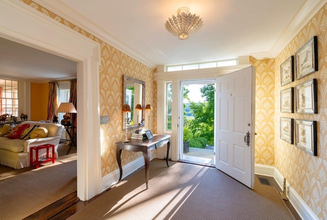 doorway to outside featuring crown molding, a chandelier, and dark hardwood / wood-style floors