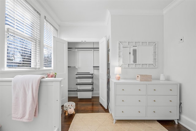 interior space featuring a closet, crown molding, baseboards, and wood finished floors