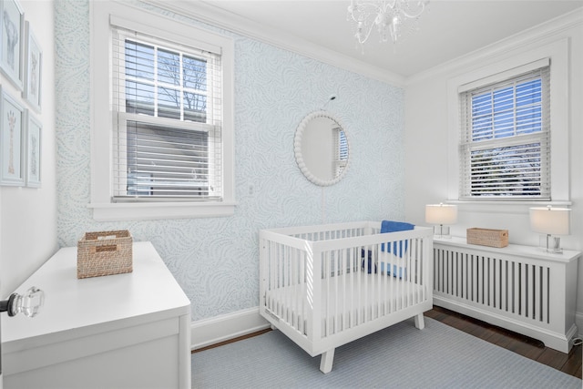 bedroom with wallpapered walls, multiple windows, baseboards, and ornamental molding