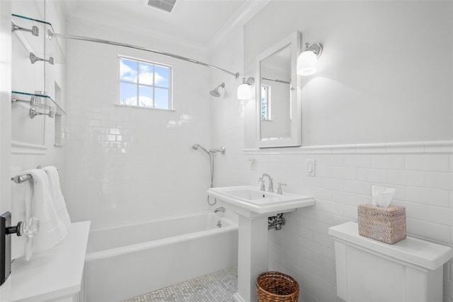 full bath featuring visible vents, toilet, crown molding, shower / bathtub combination, and tile walls