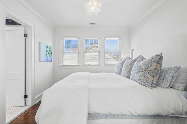 bedroom featuring a chandelier, dark wood-style flooring, visible vents, and crown molding