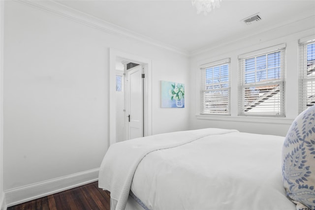 bedroom with multiple windows, ornamental molding, dark wood-style flooring, and visible vents