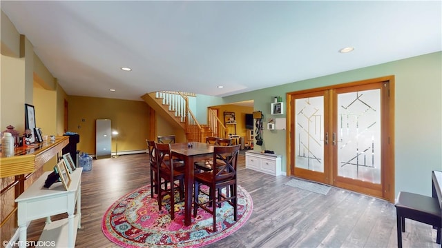 dining space with french doors, baseboard heating, and wood-type flooring