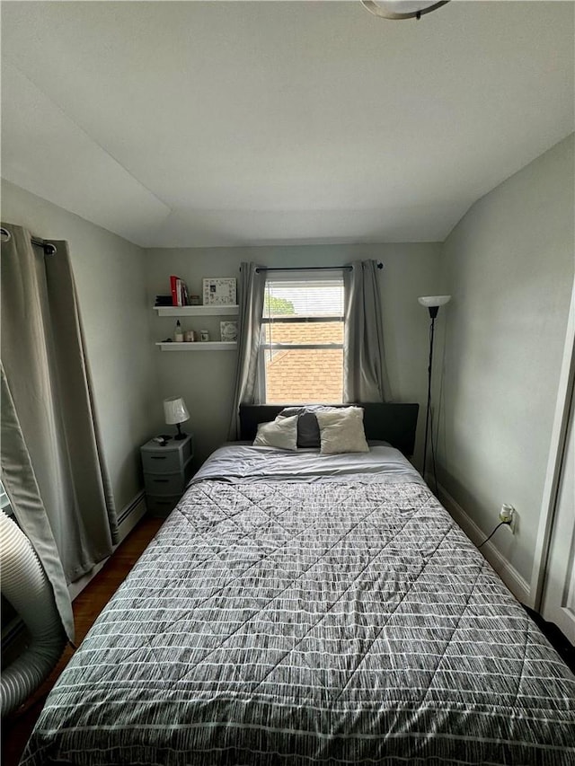 bedroom featuring dark hardwood / wood-style flooring and a baseboard heating unit