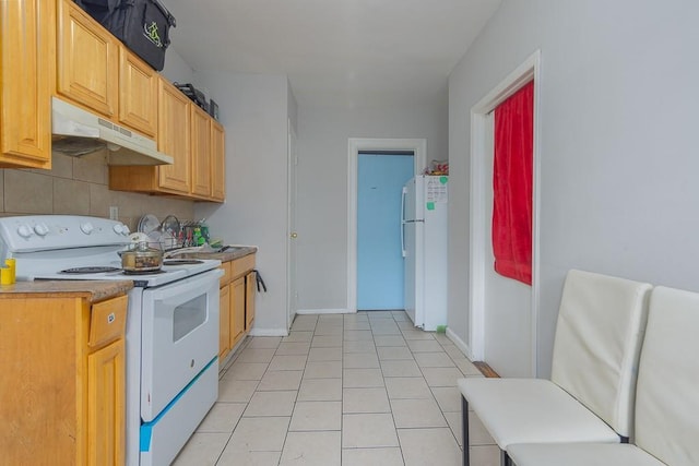 kitchen featuring light tile patterned flooring and white appliances