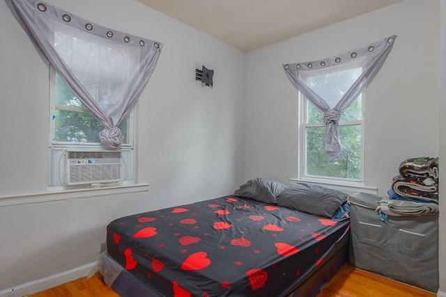 bedroom with cooling unit and light wood-type flooring