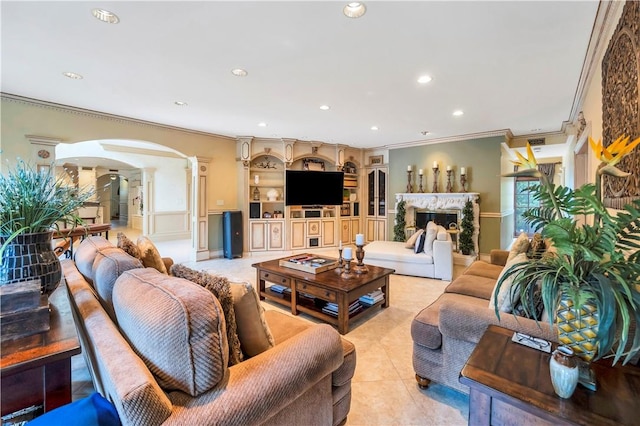 tiled living room featuring decorative columns, crown molding, and a premium fireplace