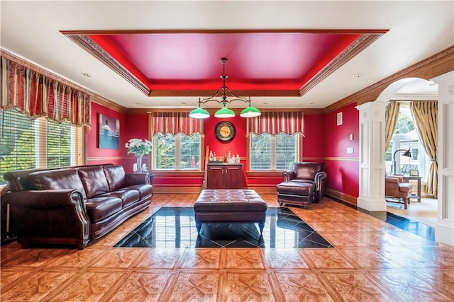 interior space with tile patterned floors, a raised ceiling, crown molding, and decorative columns