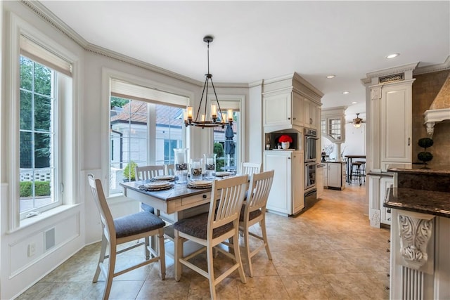 tiled dining room featuring ceiling fan with notable chandelier and crown molding