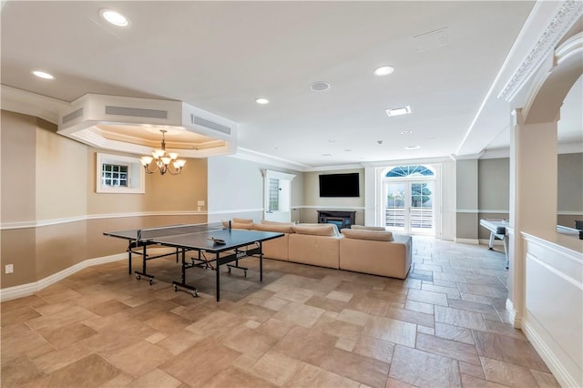 rec room with a notable chandelier and ornamental molding