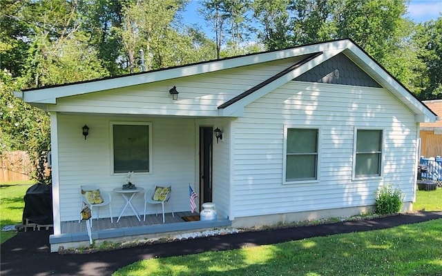 bungalow-style house featuring covered porch and a front lawn