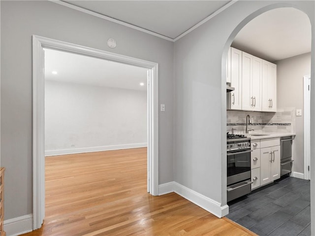 kitchen with white cabinets, high end range, dark wood-type flooring, and backsplash