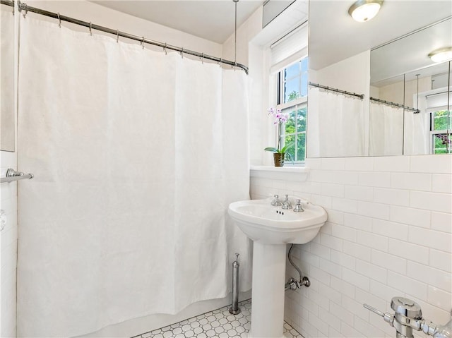 bathroom with tile patterned flooring, a shower with curtain, and tile walls