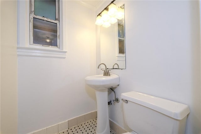 bathroom featuring toilet and crown molding