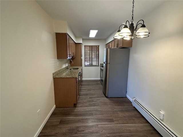 kitchen with baseboard heating, sink, decorative light fixtures, dark hardwood / wood-style floors, and stainless steel refrigerator