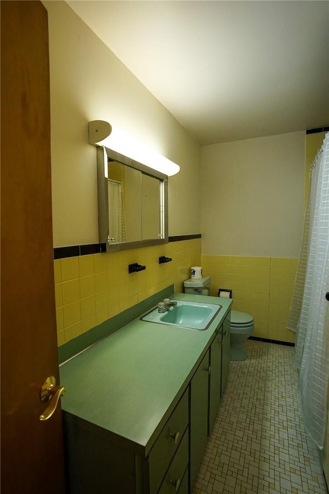 437 Lindholm Rd, Fallsburg, NY 12747 - bathroom featuring tile walls, toilet, vanity, a wainscoted wall, and curtained shower
