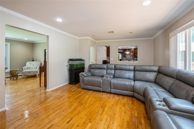 living room with ornamental molding, a baseboard radiator, and light wood-type flooring