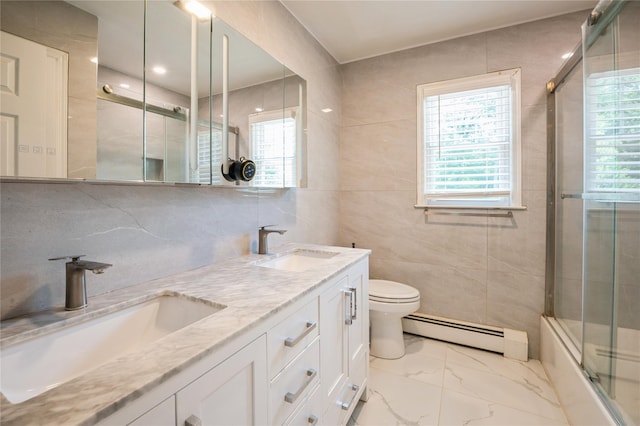 full bathroom with bath / shower combo with glass door, vanity, a healthy amount of sunlight, and a baseboard heating unit