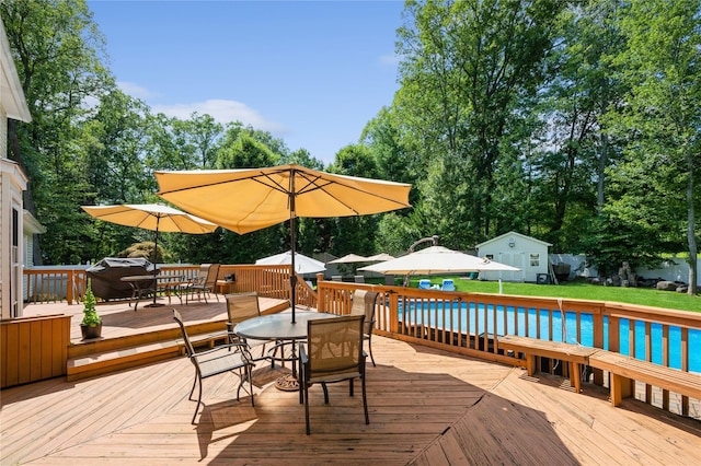 wooden deck featuring a pool and grilling area