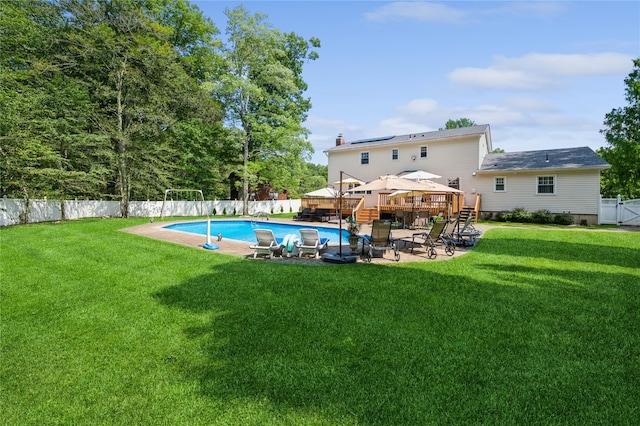 view of swimming pool featuring a lawn and a wooden deck