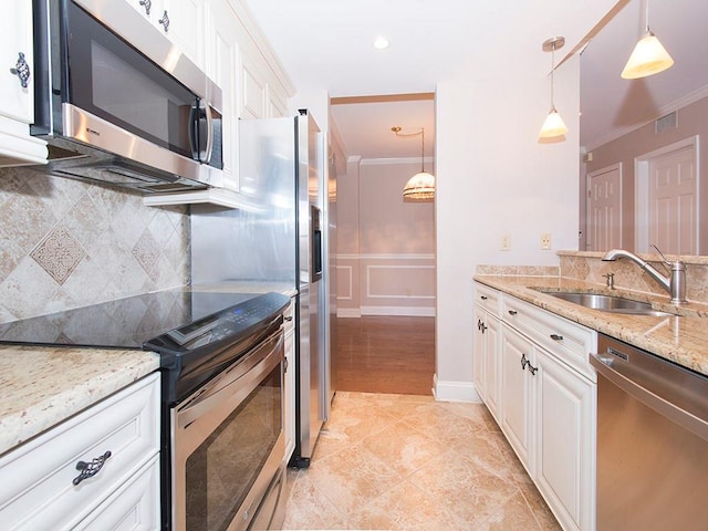 kitchen with white cabinets, hanging light fixtures, sink, light stone countertops, and appliances with stainless steel finishes