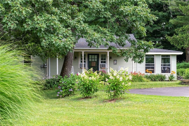 view of front of home featuring cooling unit, a front lawn, and a porch